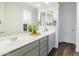 Bathroom featuring dual sinks, quartz counters, modern faucets, and a large mirror at 7180 W Tombstone Trl, Peoria, AZ 85383