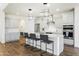 Kitchen boasts an island with seating, stainless appliances, modern lighting, and wood-look floors at 7180 W Tombstone Trl, Peoria, AZ 85383