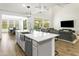 Open-concept kitchen featuring stainless steel appliances, a large island, and views into the living area at 7180 W Tombstone Trl, Peoria, AZ 85383