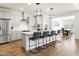 Open kitchen boasts a large center island with seating, stainless appliances, and modern lighting at 7180 W Tombstone Trl, Peoria, AZ 85383