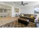 Bright living room featuring neutral tones, comfortable seating, and a modern ceiling fan at 7180 W Tombstone Trl, Peoria, AZ 85383