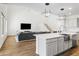 Open-concept living room and kitchen area with modern lighting and a large island with seating at 7180 W Tombstone Trl, Peoria, AZ 85383