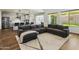 Spacious living room showcasing a corner couch, modern fixtures, and an open concept to the kitchen at 7180 W Tombstone Trl, Peoria, AZ 85383