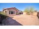 Backyard featuring a spacious dirt yard with a mature tree, block fence, and covered patio at 7405 W Elwood St, Phoenix, AZ 85043