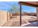 Backyard view featuring a mature tree, a block fence, and brick pavers, under a clear sky at 7405 W Elwood St, Phoenix, AZ 85043