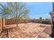 View of the spacious backyard with a mature tree, bordered by a block fence on a sunny day at 7405 W Elwood St, Phoenix, AZ 85043
