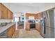 Functional kitchen with stainless steel appliances, oak cabinets, and access to the living area at 7405 W Elwood St, Phoenix, AZ 85043