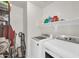 Well-lit laundry room featuring white appliances, storage shelves, and ample space for tasks at 7405 W Elwood St, Phoenix, AZ 85043