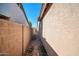 View of the side yard, featuring a gravel walkway between the block fence and house at 7405 W Elwood St, Phoenix, AZ 85043
