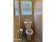 Bathroom featuring a standard white toilet and window with blinds for natural light at 7422 W Superior Ave, Phoenix, AZ 85043