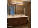 Bathroom with dual sinks and large vanity mirror with plenty of overhead lighting at 7422 W Superior Ave, Phoenix, AZ 85043