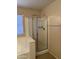 Bathroom featuring glass shower with silver trim and tub beneath a window with blinds at 7422 W Superior Ave, Phoenix, AZ 85043