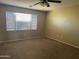 Bedroom with window, neutral carpet, ceiling fan, and walls at 7422 W Superior Ave, Phoenix, AZ 85043