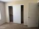 Bedroom features standard closet with sliding doors, neutral color walls, and carpeted floors at 7422 W Superior Ave, Phoenix, AZ 85043