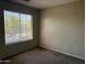 Bedroom with standard window letting in light with tan walls and carpet floors at 7422 W Superior Ave, Phoenix, AZ 85043
