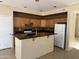 Spacious kitchen featuring wooden cabinets, dark countertops and an island at 7422 W Superior Ave, Phoenix, AZ 85043