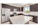 Modern kitchen with stainless steel appliances, dark cabinetry, a large island, and white herringbone backsplash at 802 W Buist Ave, Phoenix, AZ 85041