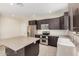 Modern kitchen with a large island, stainless steel appliances, dark cabinets, and bright recessed lighting at 802 W Buist Ave, Phoenix, AZ 85041