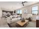 Bright living room featuring neutral colors, a ceiling fan, tile floors, and an open floor plan with a modern kitchen at 802 W Buist Ave, Phoenix, AZ 85041