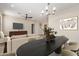 Open concept living area with a large dining table, modern chandelier, and a comfortable seating area with TV at 802 W Buist Ave, Phoenix, AZ 85041