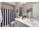 Bathroom featuring white countertops, vanity and a shower with a black and white striped curtain at 9723 W Patrick Ln, Peoria, AZ 85383
