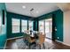 Bright dining room with teal walls, dark table, neutral chairs, and a glass door leading to the backyard at 9723 W Patrick Ln, Peoria, AZ 85383