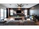 Contemporary living room with dark walls, wood floors, modern furnishings, and a sliding door to the patio at 9723 W Patrick Ln, Peoria, AZ 85383