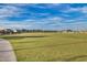 Expansive open field with well-maintained lawn and views of homes and mountains in the distance at 9723 W Patrick Ln, Peoria, AZ 85383