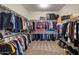 Organized walk-in closet with ample storage, shelving, and rods for hanging clothes and storage for shoes at 9723 W Patrick Ln, Peoria, AZ 85383