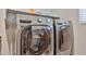 Laundry room featuring high-efficiency washer and dryer, and storage shelves at 10739 W Sierra Pinta Dr, Peoria, AZ 85373
