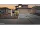 Two-story home featuring a large driveway and neutral-colored exterior with a red tile roof at 11215 W Heatherbrae Dr, Phoenix, AZ 85037