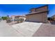 Home exterior with a spacious driveway, gravel landscaping, and a well-maintained yard under a clear blue sky at 11215 W Heatherbrae Dr, Phoenix, AZ 85037
