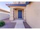 Inviting front entrance with a blue door, arched porch, and desert landscaping adding charm and curb appeal at 11215 W Heatherbrae Dr, Phoenix, AZ 85037