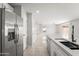 Modern kitchen with stainless steel refrigerator, island with quartz countertop, and tile flooring at 11215 W Heatherbrae Dr, Phoenix, AZ 85037