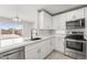 Bright kitchen featuring stainless steel appliances, white cabinetry, and a modern sink at 11215 W Heatherbrae Dr, Phoenix, AZ 85037