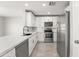 Modern kitchen with white cabinets, stainless steel appliances, and quartz countertops at 11215 W Heatherbrae Dr, Phoenix, AZ 85037