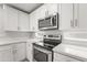 Close-up of the kitchen with stainless steel stove, microwave, and quartz countertops at 11215 W Heatherbrae Dr, Phoenix, AZ 85037