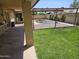 Backyard with a covered patio, grass, steel fencing and an empty in-ground pool at 12016 N 45Th Ave, Glendale, AZ 85304
