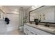Modern bathroom with double vanity, white cabinets, large mirror, and shower with patterned curtain at 12712 W Corona Ave, Avondale, AZ 85323