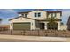 Charming two-story home featuring a tan exterior, terracotta roof, a garage and a well-manicured front yard at 12712 W Corona Ave, Avondale, AZ 85323