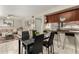Open-concept dining area features a sleek black table and chairs, seamlessly connecting to the kitchen's breakfast bar at 1402 E Guadalupe Rd # 114, Tempe, AZ 85283