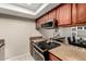Kitchen with stainless steel appliances, a flat top electric stove, granite countertops, and wood cabinetry at 1402 E Guadalupe Rd # 114, Tempe, AZ 85283