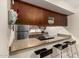 Kitchen features granite countertops, stainless steel appliances, a kitchen bar with seating, and wooden cabinets at 1402 E Guadalupe Rd # 114, Tempe, AZ 85283