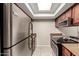 Galley kitchen with a sky light, stainless steel appliances, granite countertops, and wooden cabinets at 1402 E Guadalupe Rd # 114, Tempe, AZ 85283