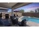 Inviting backyard space featuring a pool, spa, outdoor kitchen, fire pit, and lush landscaping for outdoor enjoyment at 14393 W Wethersfield Rd, Surprise, AZ 85379