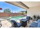 Relaxing backyard featuring a pool, spa, and comfortable seating area with a fire pit at 14393 W Wethersfield Rd, Surprise, AZ 85379