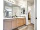 Bathroom with double vanity, large mirrors, and a view of the walk in closet at 14393 W Wethersfield Rd, Surprise, AZ 85379