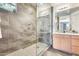 Modern bathroom with a glass shower enclosure, tiled walls, and sleek vanity at 14393 W Wethersfield Rd, Surprise, AZ 85379