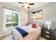 Bright bedroom with a large window, ceiling fan and comfortable bed with stylish decor at 14393 W Wethersfield Rd, Surprise, AZ 85379