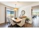 Dining room features a wooden table with seating for four, statement lighting, and a window view at 14393 W Wethersfield Rd, Surprise, AZ 85379